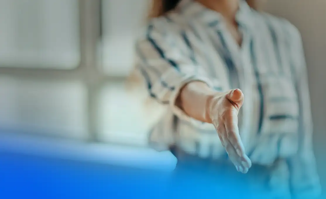 Ausgestreckte Hand heißt willkommen Eine ausgestreckte Hand soll den Handschlag zum Arbeitsvertrag darstellen